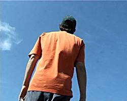 Back view of man against blue sky.
