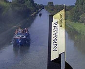 Cross fade from a narrowboat on the river to a signpost.