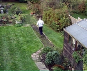 Shot from high above of man running down garden.