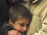 Father comforts older boy.